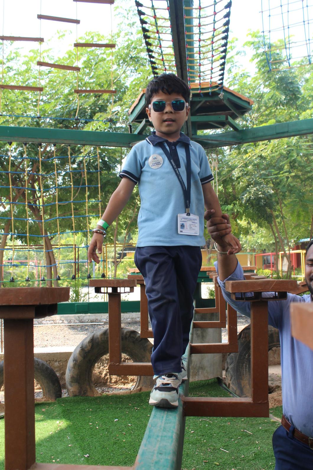 Student walking on balance beam with instructor support