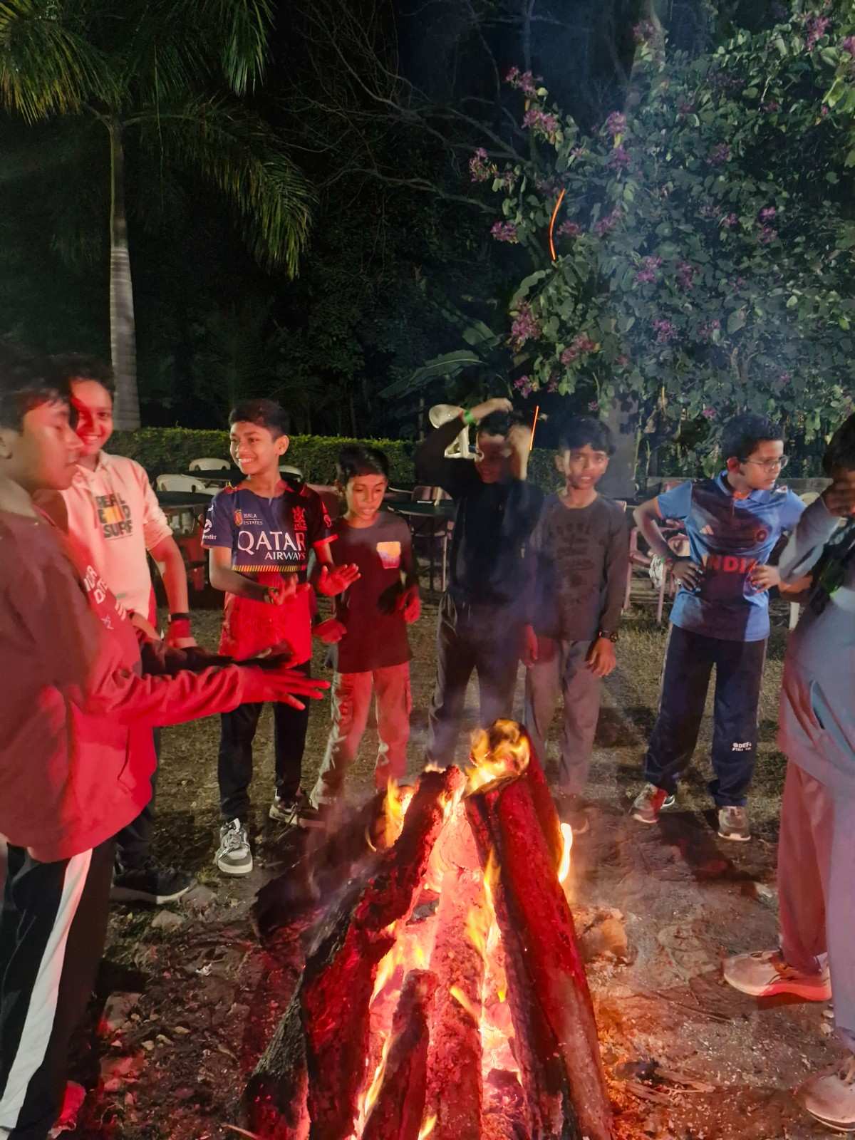 Boys warming hands at campfire