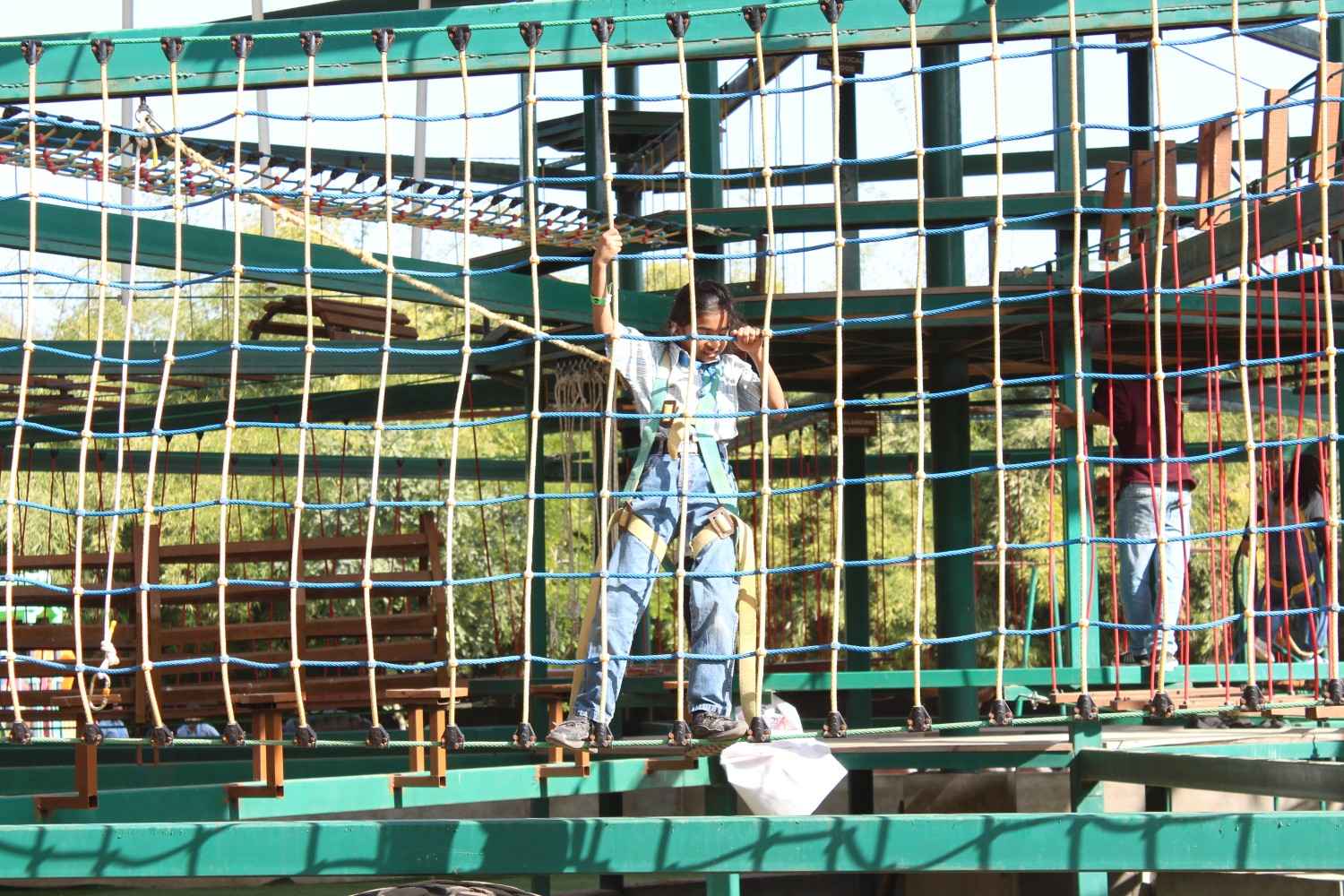 Student climbing rope net obstacle