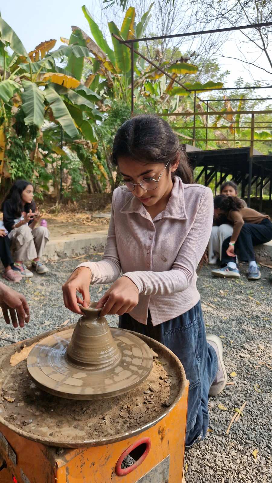 Girl shaping clay pot