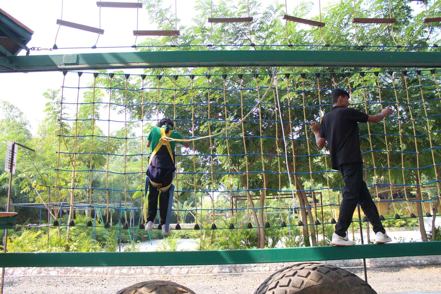 Student navigating high cargo net obstacle