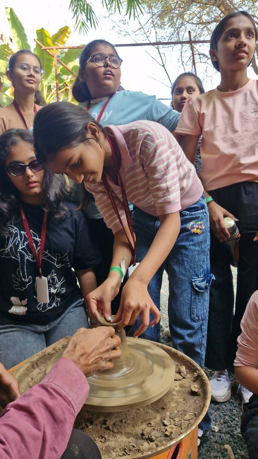 Student learning traditional pottery making on a wheel