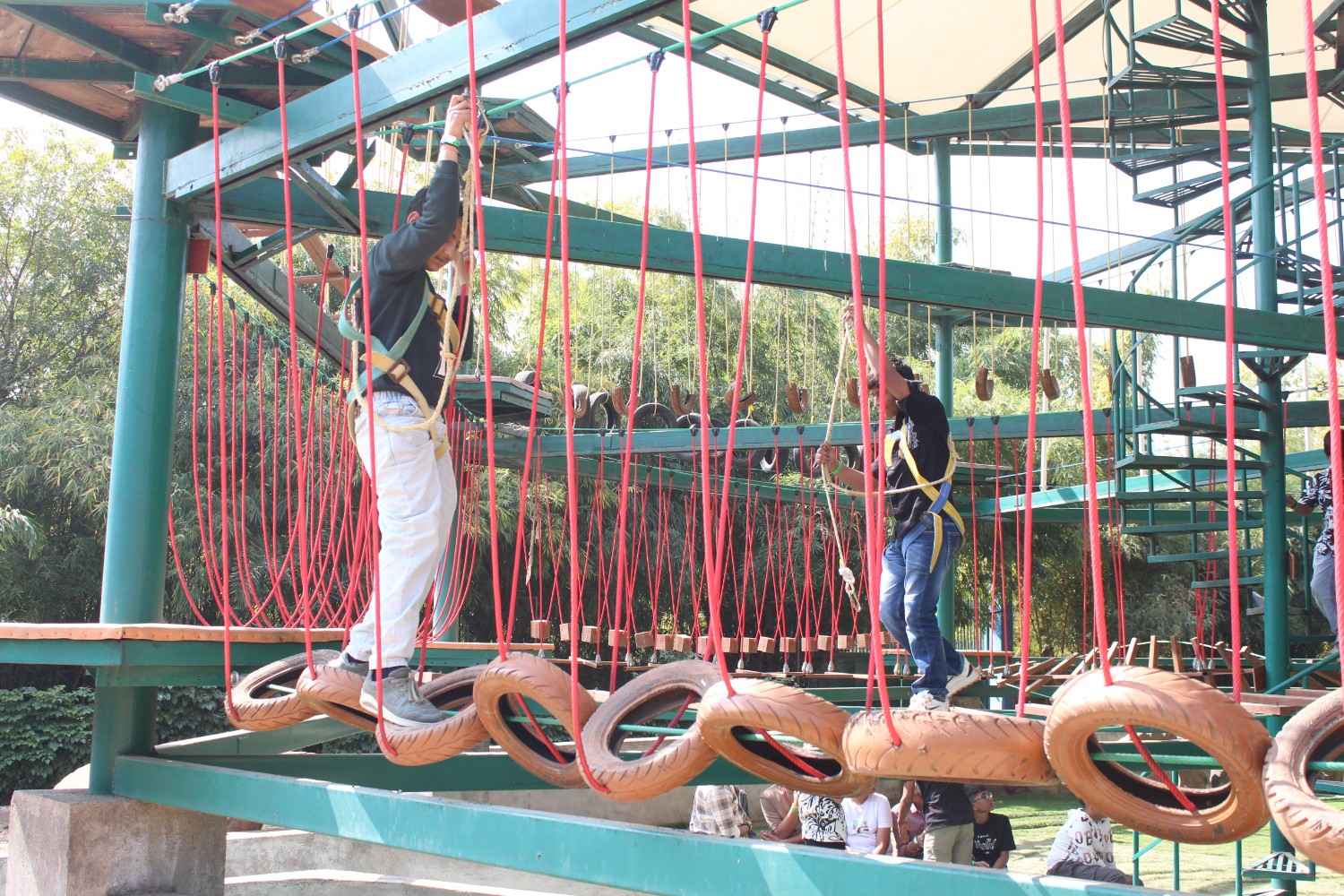 Student navigating a tire bridge challenge at an adventure camp
