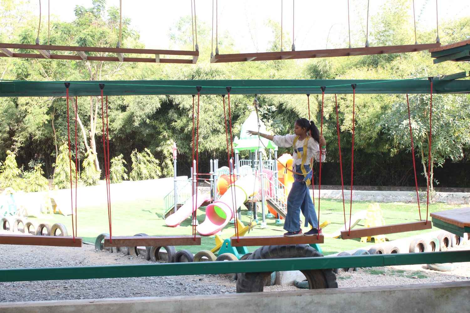 Young student carefully crossing a wooden plank adventure bridge