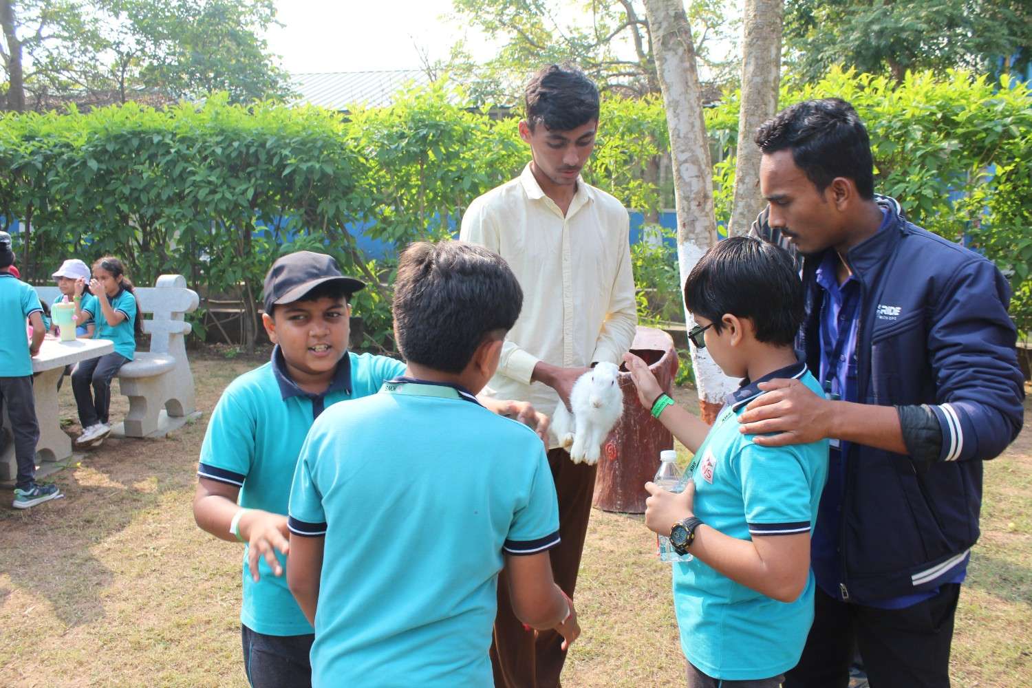 Students interacting with and petting rabbits at a petting zoo