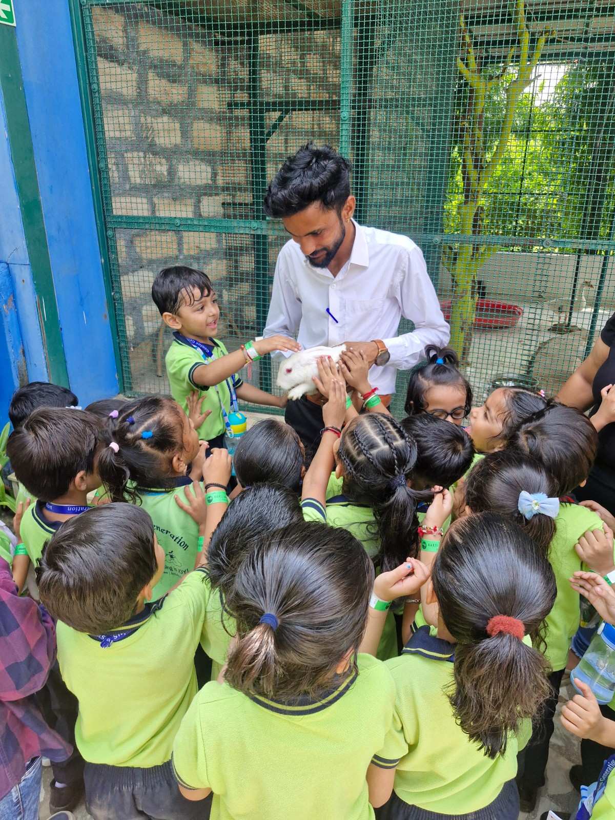 Children petting white rabbit with instructor