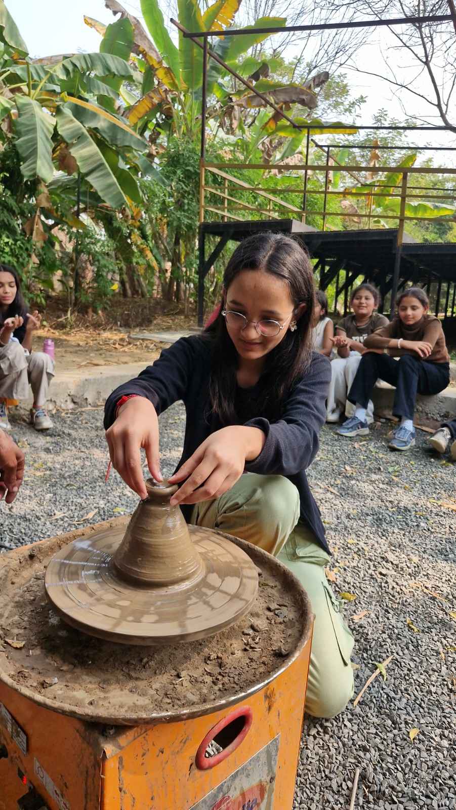 Student making pottery on wheel