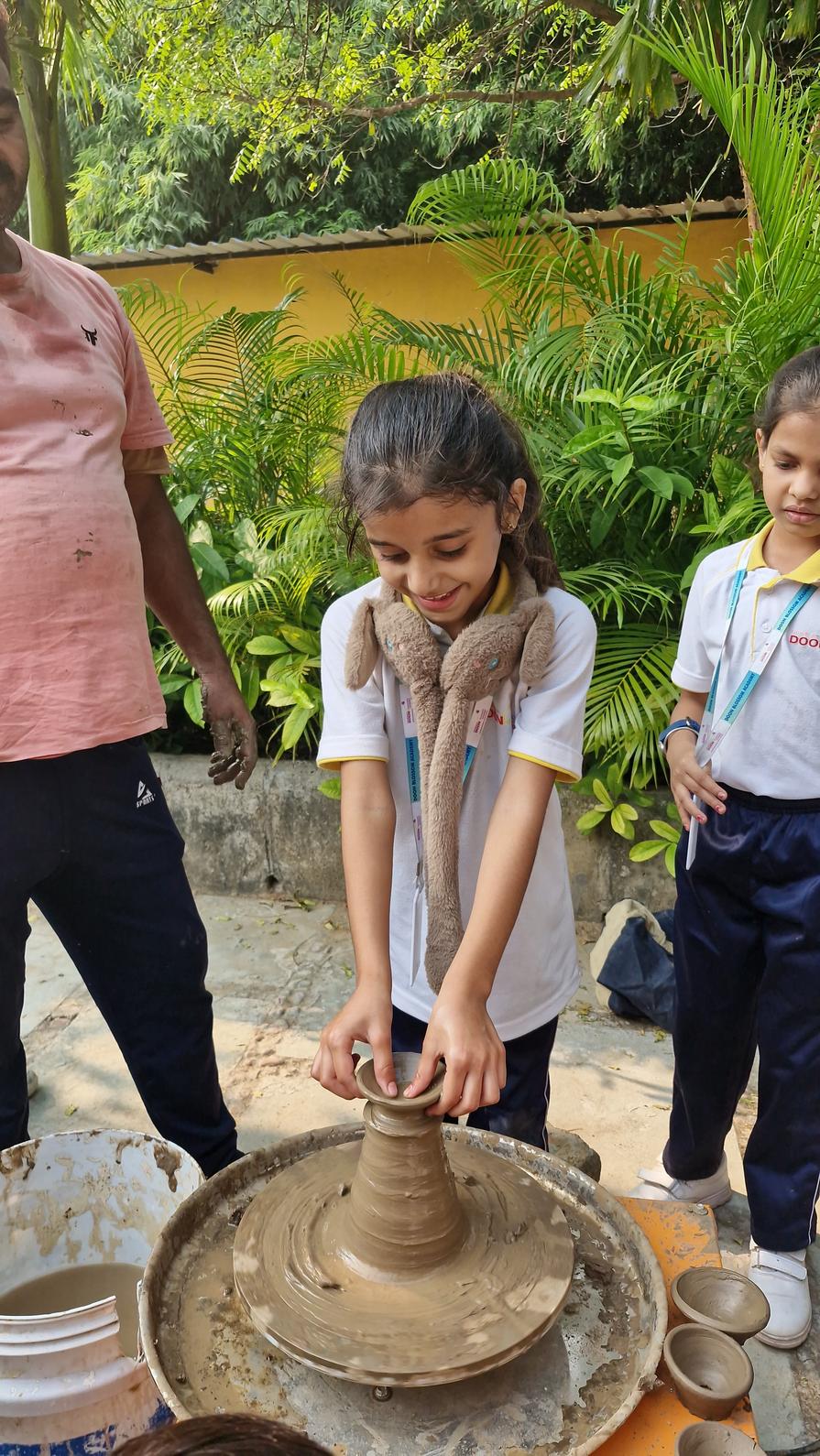 Student trying pottery making on wheel