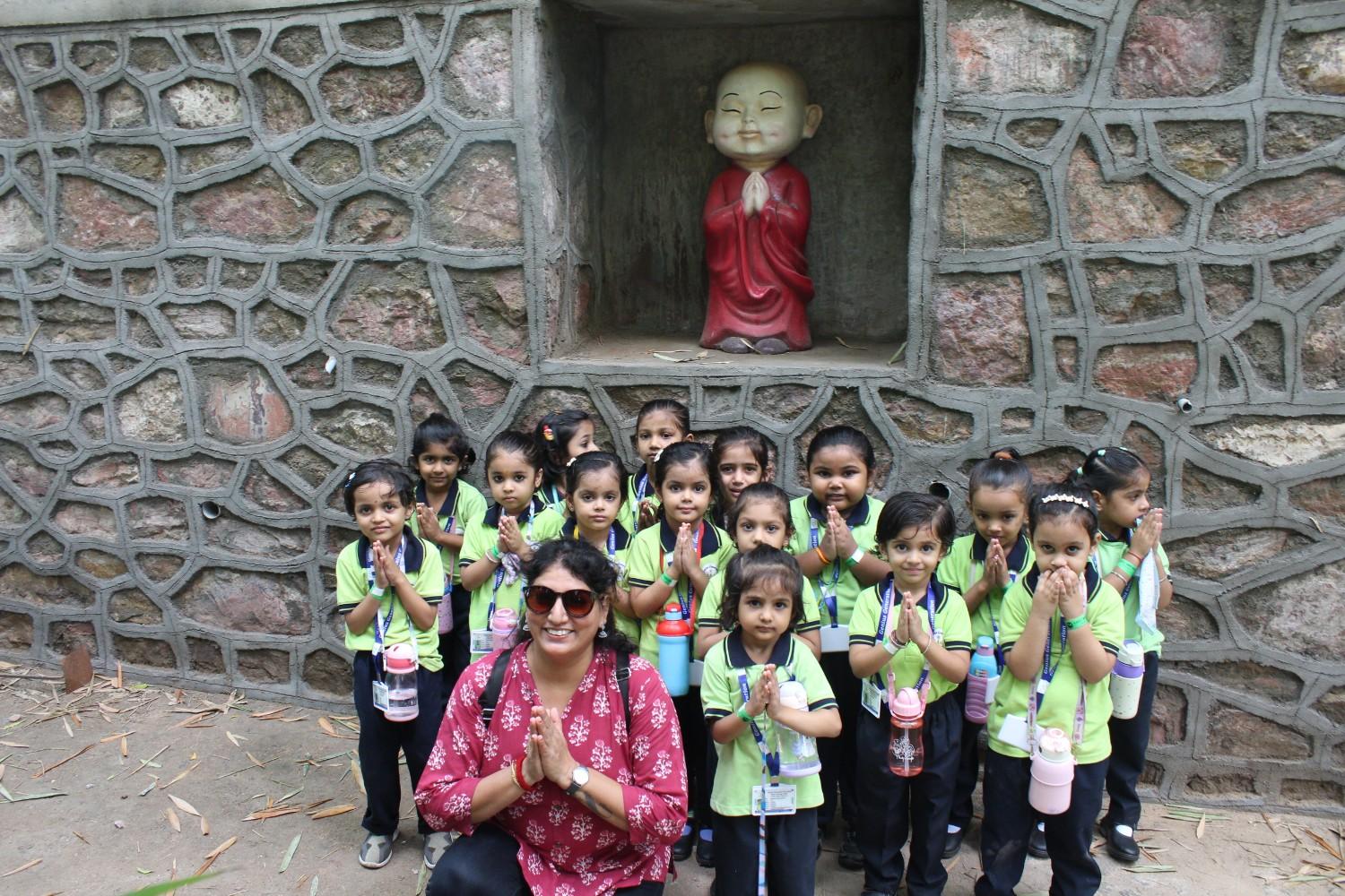 School group photo near stone Buddha statue