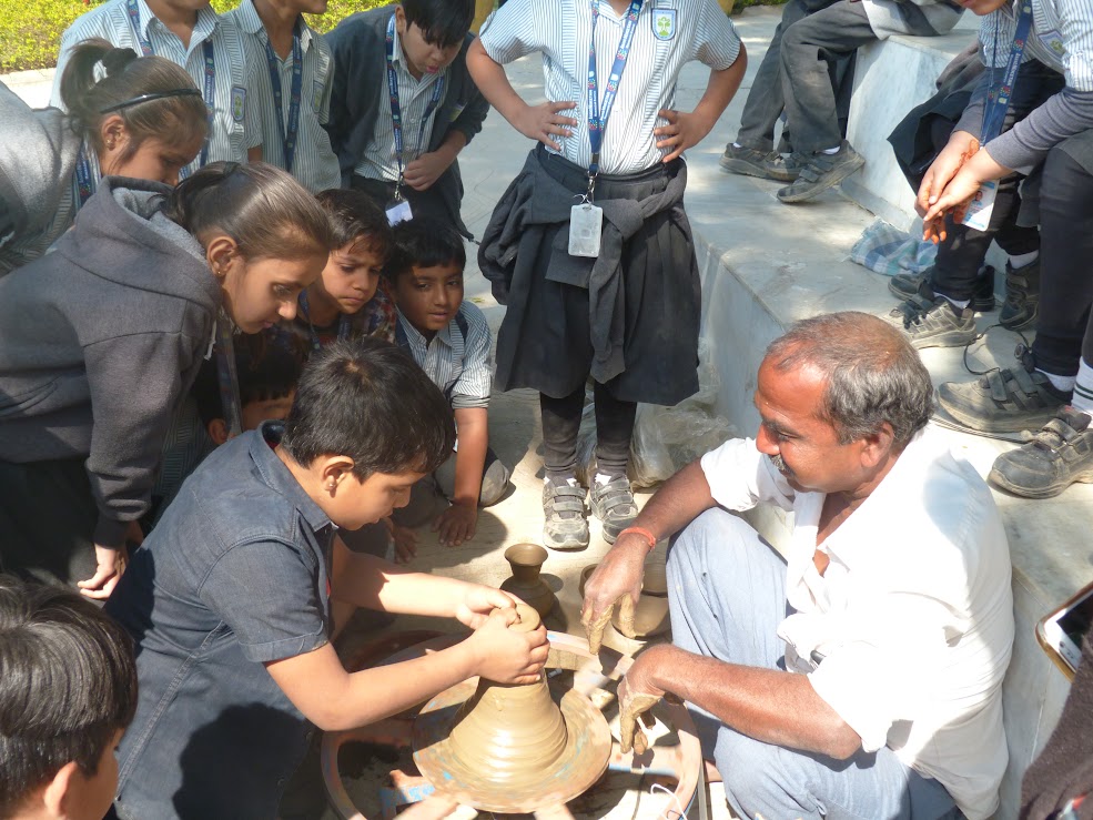 Instructor teaching pottery skills to students at camp