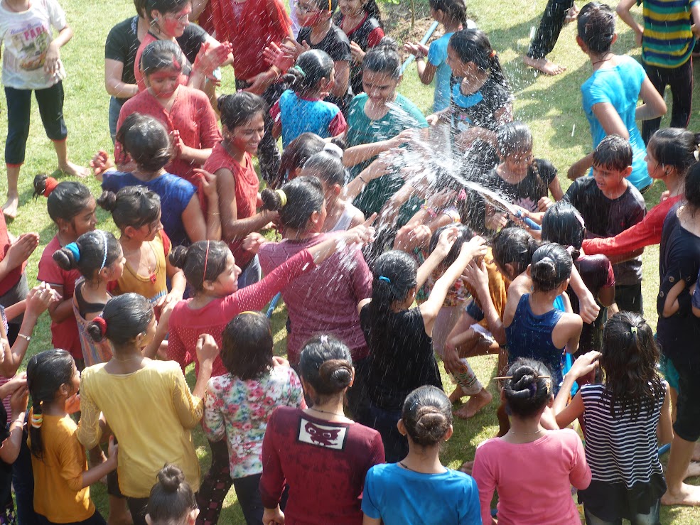 Students enjoying water sprinklers and rain dance activity