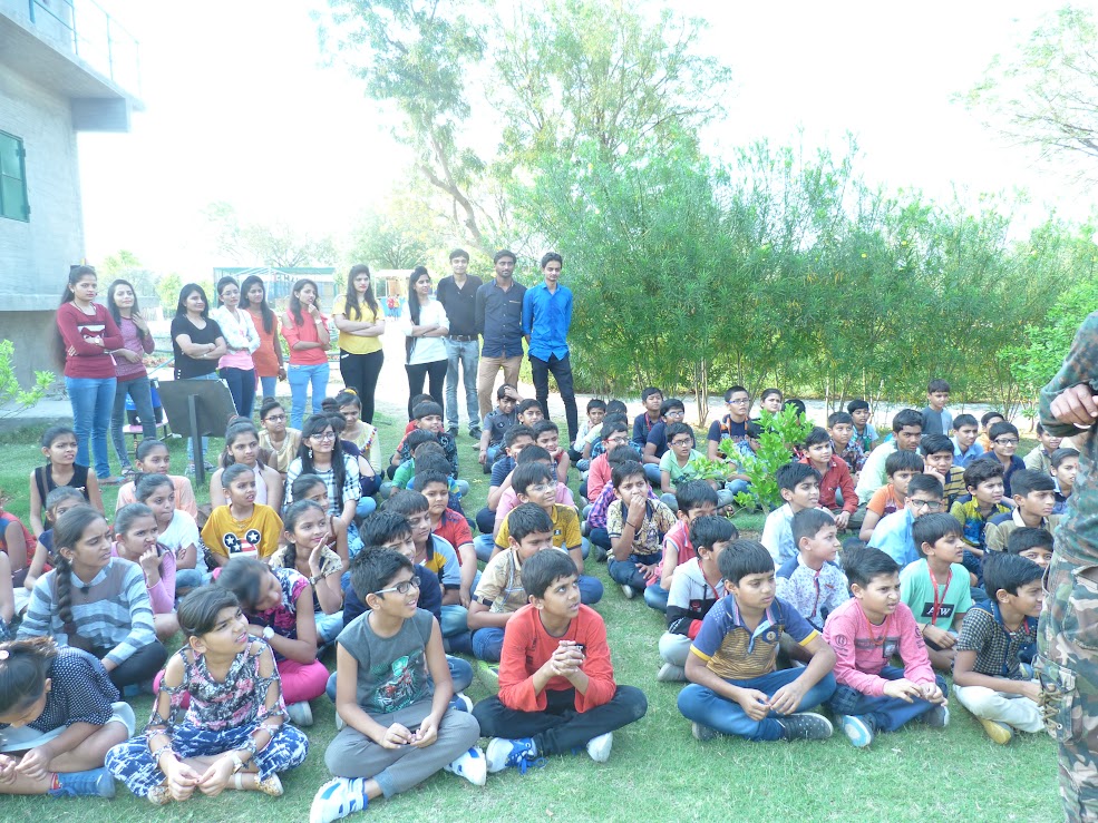 Large group of students listening to instructions on the grass