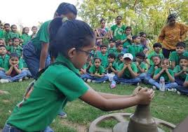 Green shirt students watching clay modeling